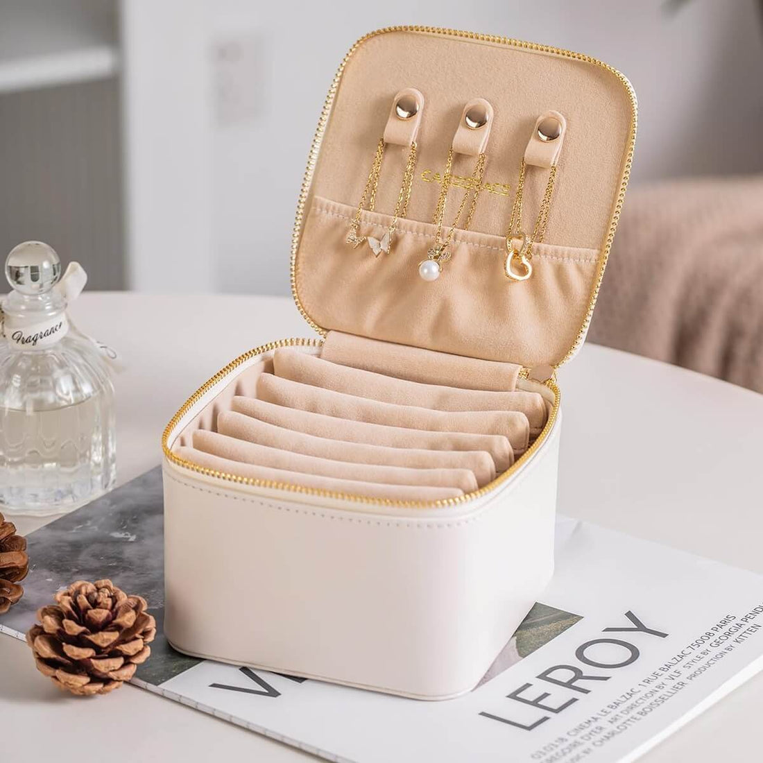 Compact travel jewelry box open showing necklace hooks and ring slots
