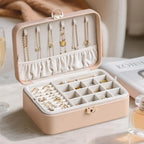 Pink 2-layer lockable jewelry box closed on marble table with perfume and champagne, lifestyle scene