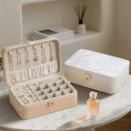 White and pink 2-layer lockable jewelry boxes displayed open with removable tray on marble table
