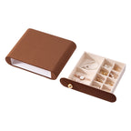 A brown velvet jewelry drawer organizer shown open with pearl bracelets and a watch on a white background.