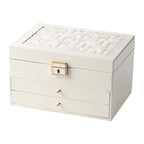A clean studio shot of a cream-white 3-tier leather jewelry organizer box closed on a solid white background, highlighting its quilted lid texture and gold hardware.