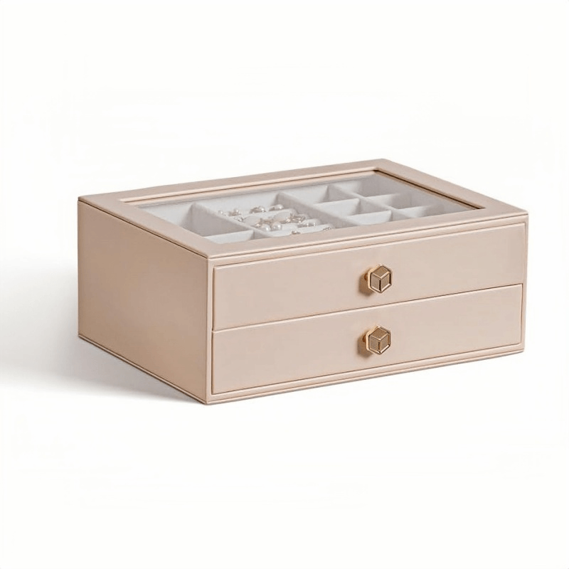 Pink 2-layer stackable jewelry box with glass lid and gold geometric knobs, being lifted