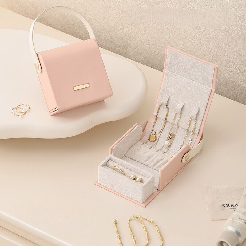 Pink handbag jewelry box open showing necklace slots and ring compartment