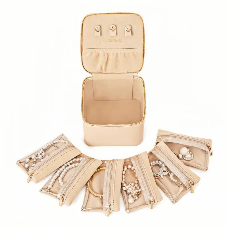 Mini travel jewelry box with 6 velvet zipper pockets displayed open alongside the box
