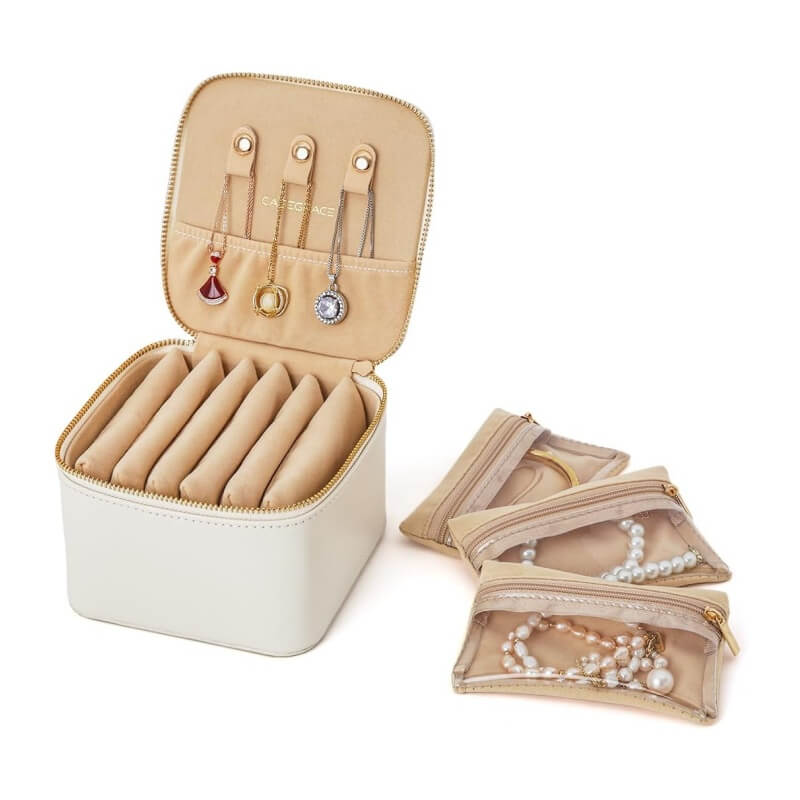 White mini travel jewelry box open with 6 velvet zipper pockets laid out flat
