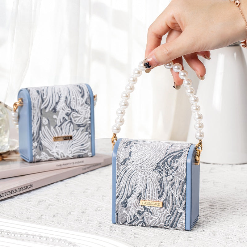 Hand lifting pearl handle jewelry box by pearl strap