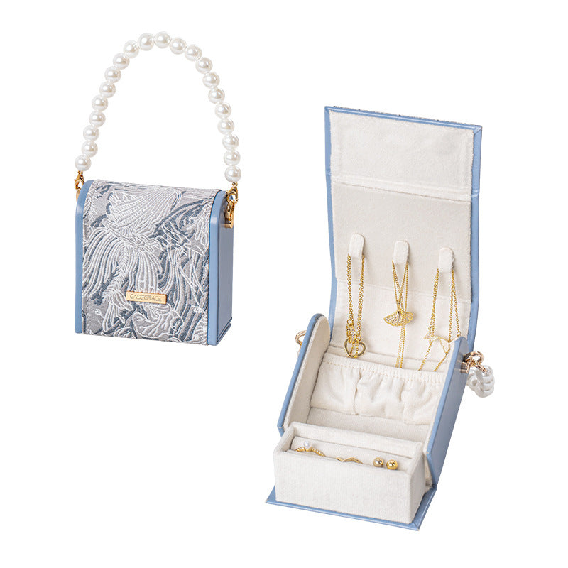 3D embroidered jacquard fabric and leather jewelry box with pearl handle, flat lay view